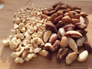 Nuts - brazil, almonds, cashew and pine nuts on a wooden board.