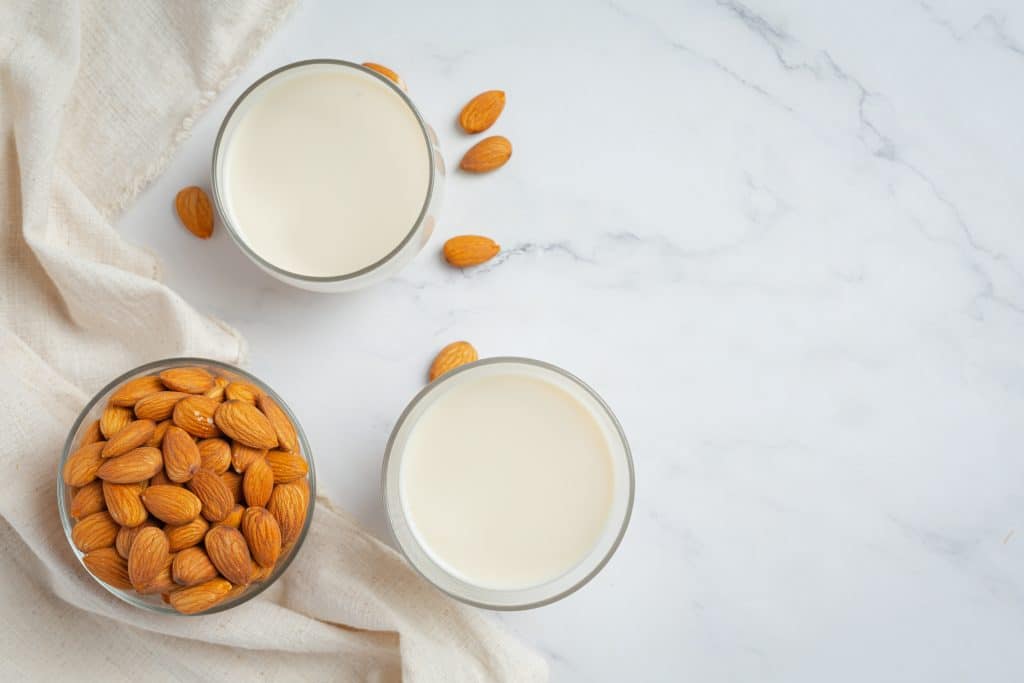 Almond milk with almond on marble background