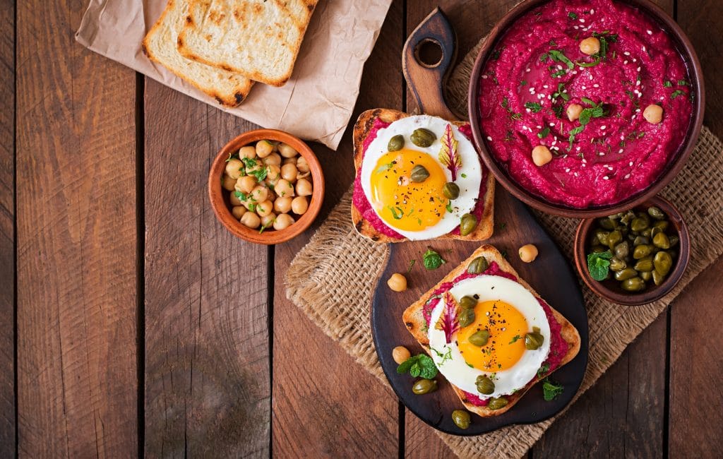 Diet sandwiches with beet root hummus, capers and egg. Top view