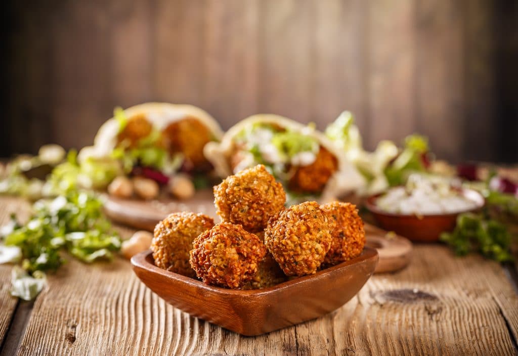 Fresh falafel balls on a wooden bowl