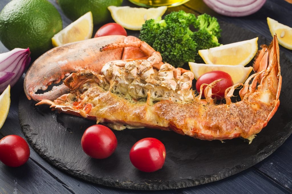 Lobster Thermidor, grilled lobster stuffed with cream and cheese, served with lemon，Boston lobster with cheese
