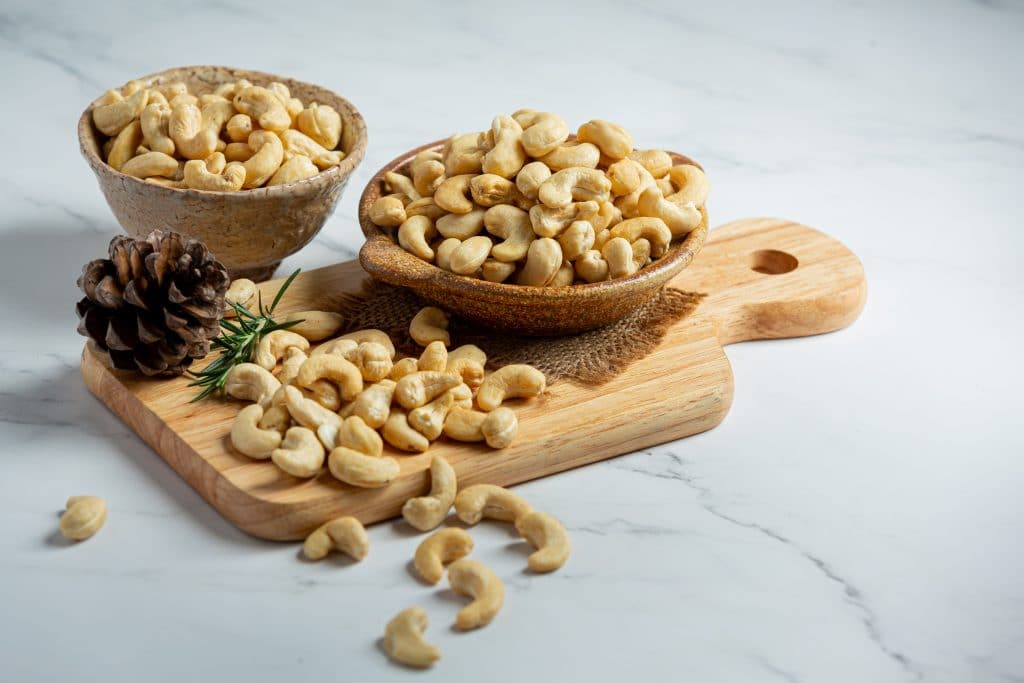 Raw cashews nuts in bowl on marble background