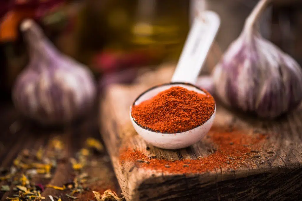 Red paprika powder on spoon.