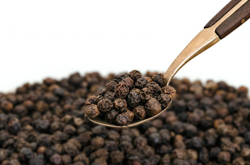 Whole Black Pepper on Old Spoon
