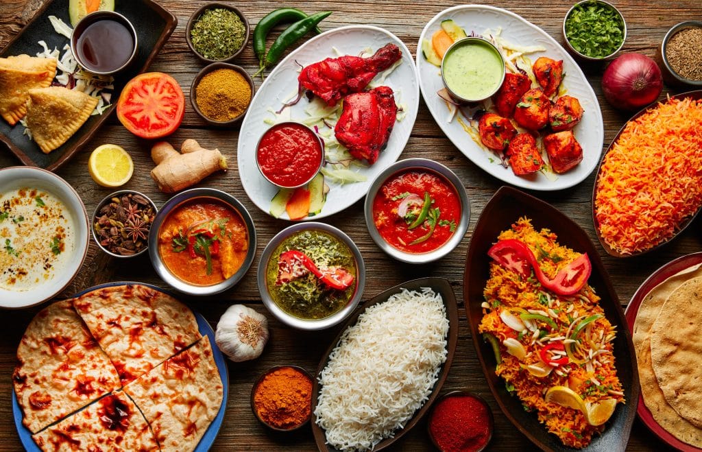 Assorted Indian recipes food various with spices and rice on wooden table