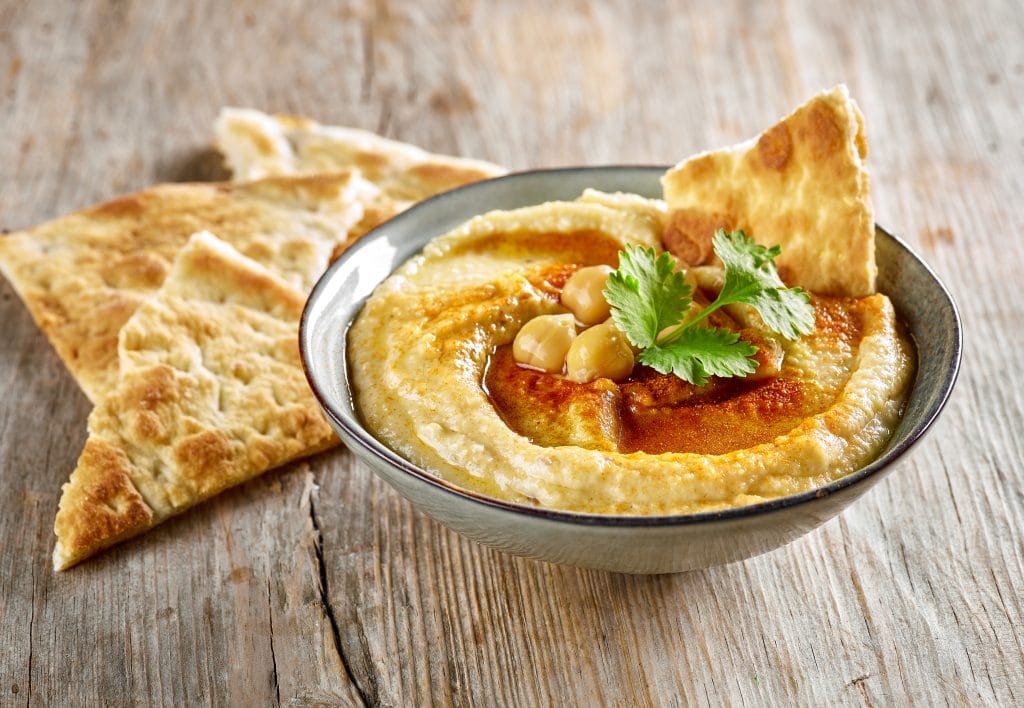 bowl of hummus on old wooden table