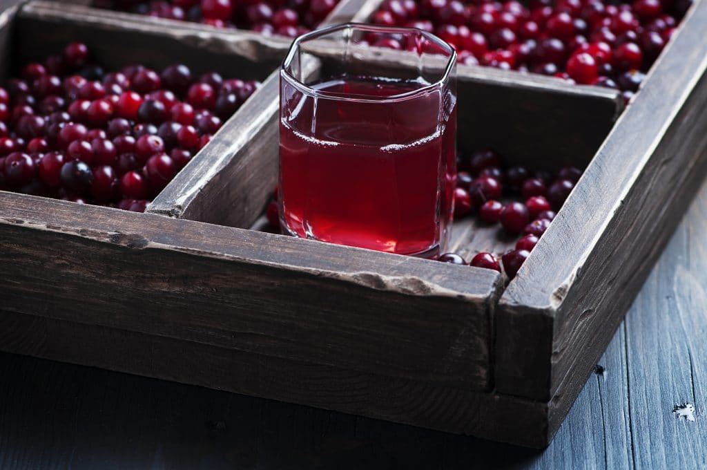 Fresh cranberry juice on the wooden table, selective focus