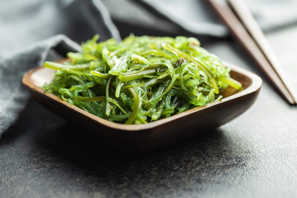 Green wakame. Seaweed salad in wooden bowl.