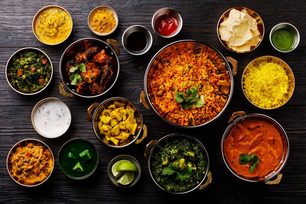 Indian food Curry butter chicken, Palak Paneer, Chiken Tikka, Biryani, Vegetable Curry, Papad, Dal, Palak Sabji, Jira Alu, Rice with Saffron on dark background