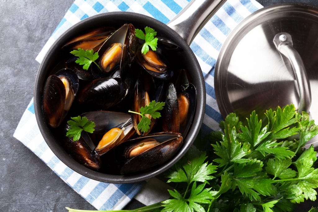 Mussels in copper on stone table. Top view