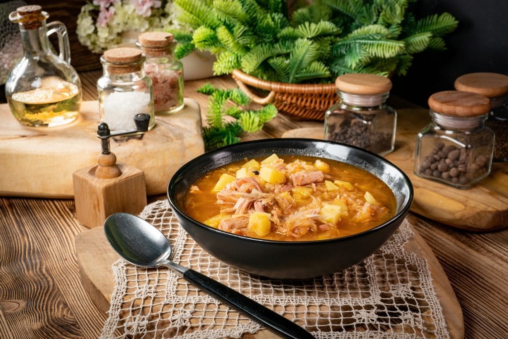Traditional russian soup with cabbage on wooden table.