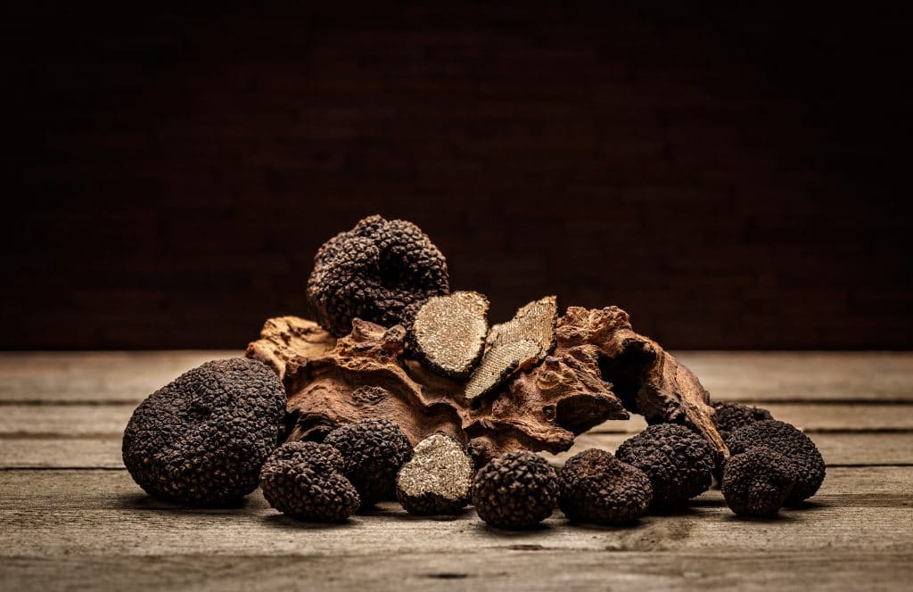 Black truffles mushrooms on rustic wooden table with free text space