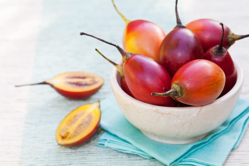 Tamarillo fruits with slice on blue napkin Outdoor background