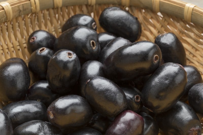 Whole fresh Jamun berries in a basket